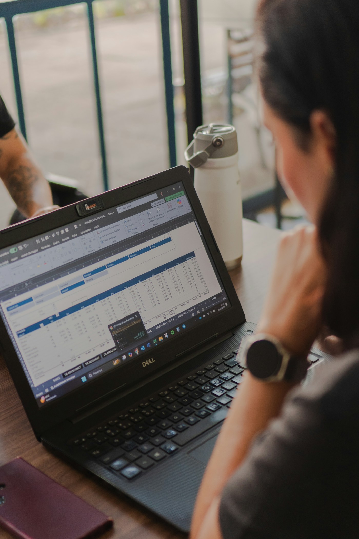 A finance professional reviewing spreadsheet data on a laptop
